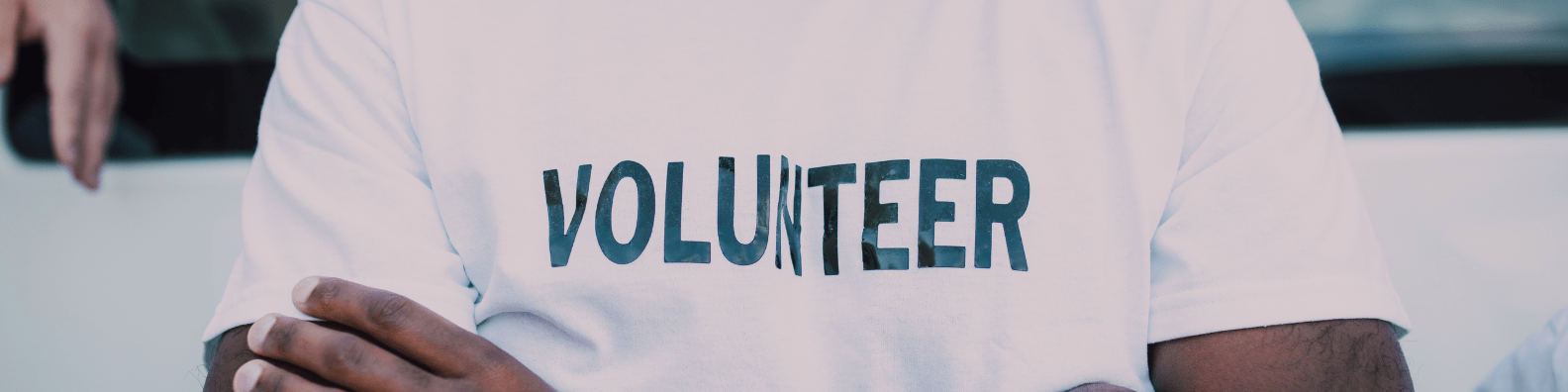 A person in a white t-shite with the word volunteer on it