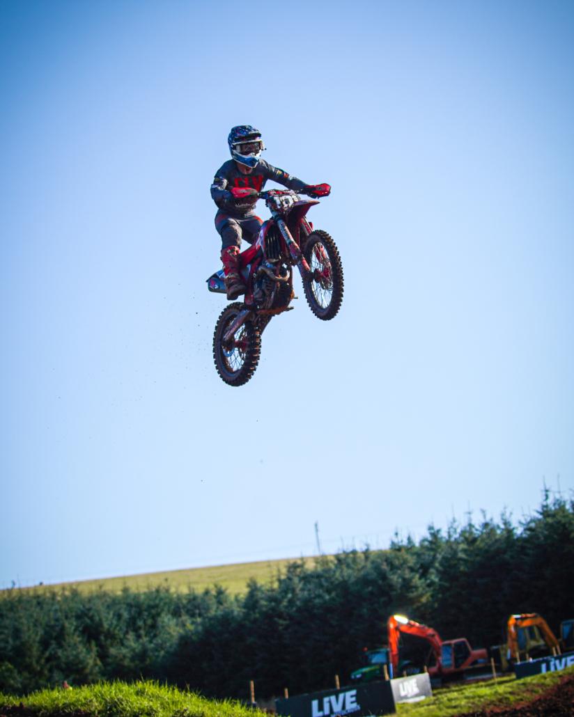 A motor biker in mid air doing a stunt