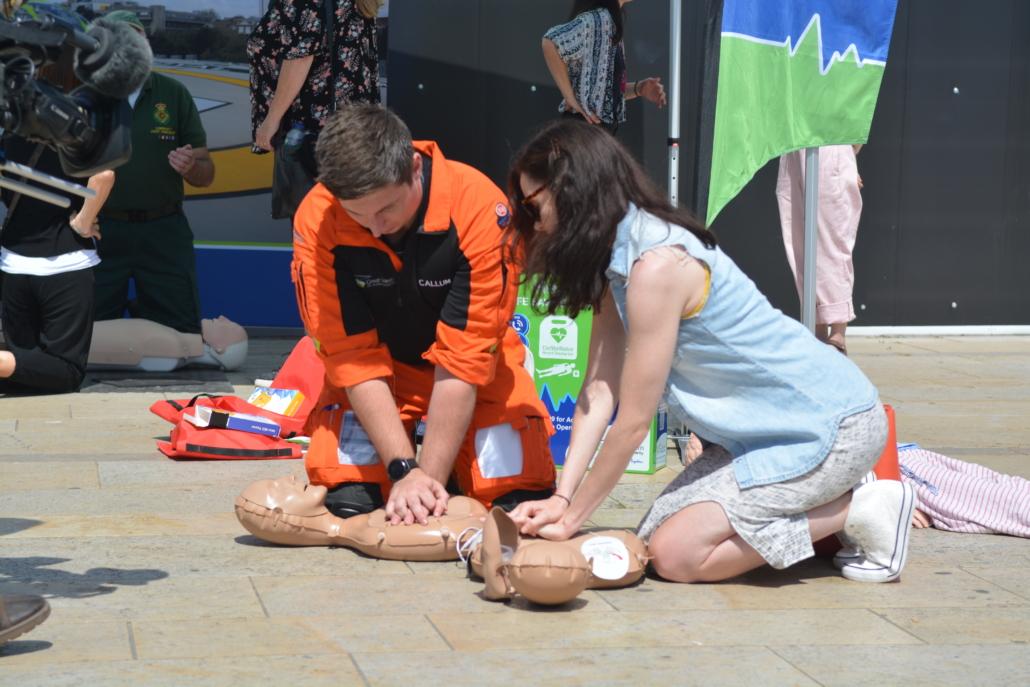 A paramedic and volunteer training to undertake CPR.